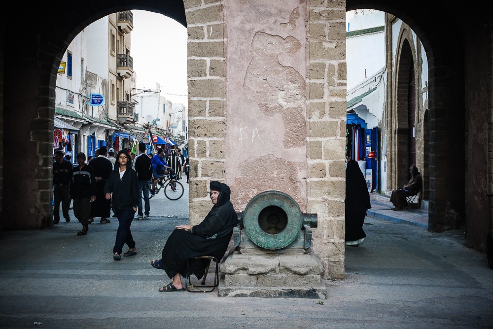 Old woman sitting at the gateway to the Medina in Essaouira, Morocco