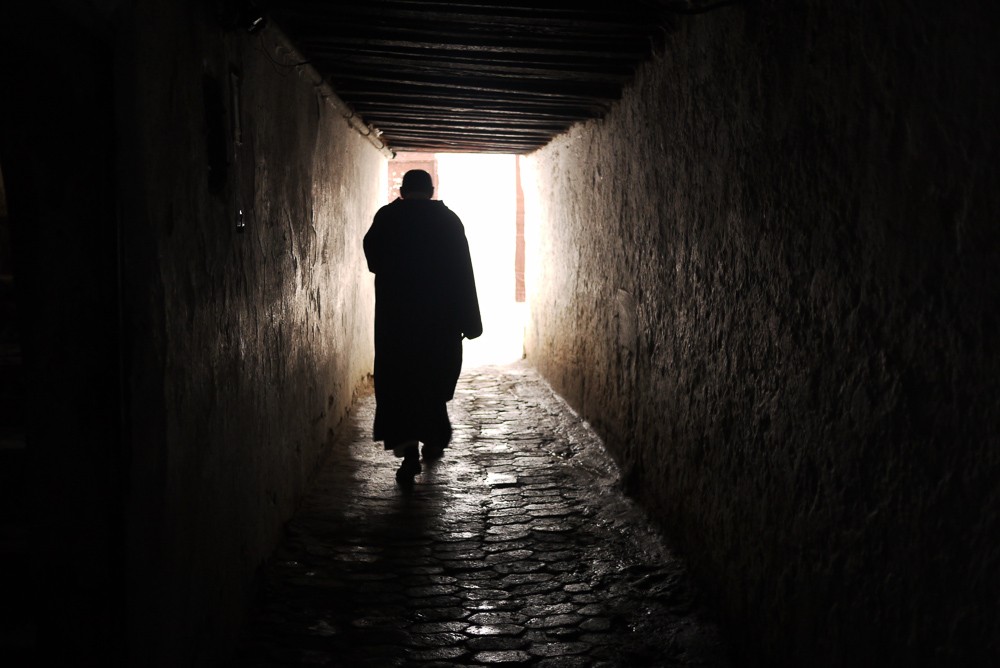 Moroccan Man Walking Through Fes Tunnel In Old Souk