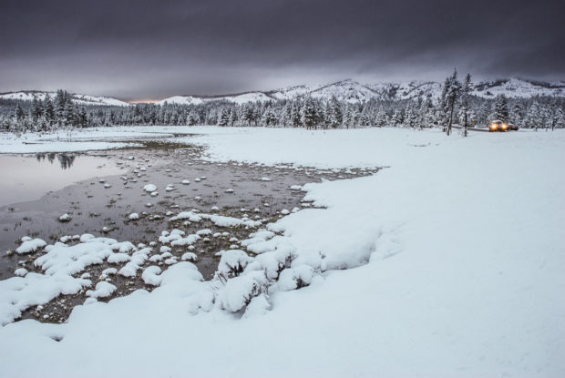 Car driving through the snow near Canyon Village in Yellowstone