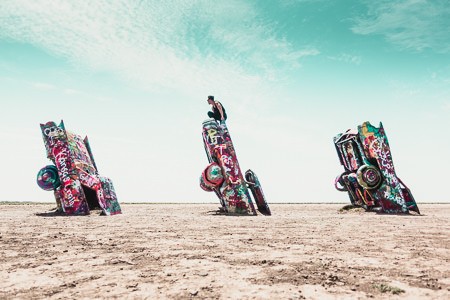 Man sitting on cadillac wreck in Amarillo, Texas