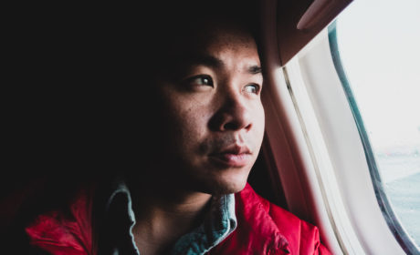 Man looking out of airplane window in first class