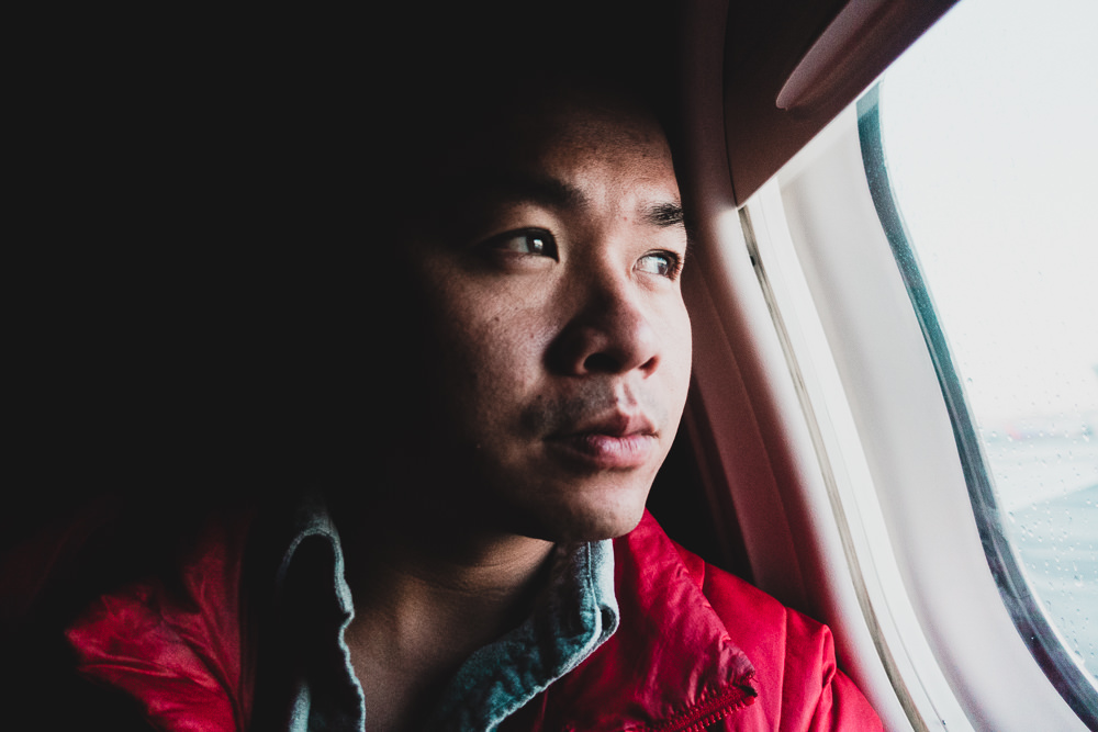 Man looking out of airplane window in first class