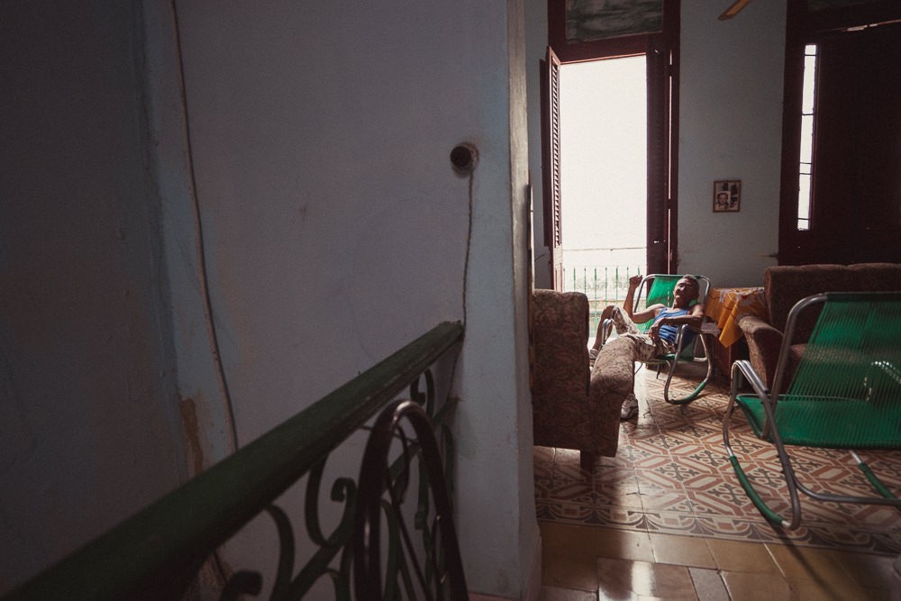 Portrait of old Cuban man on chair in Havana