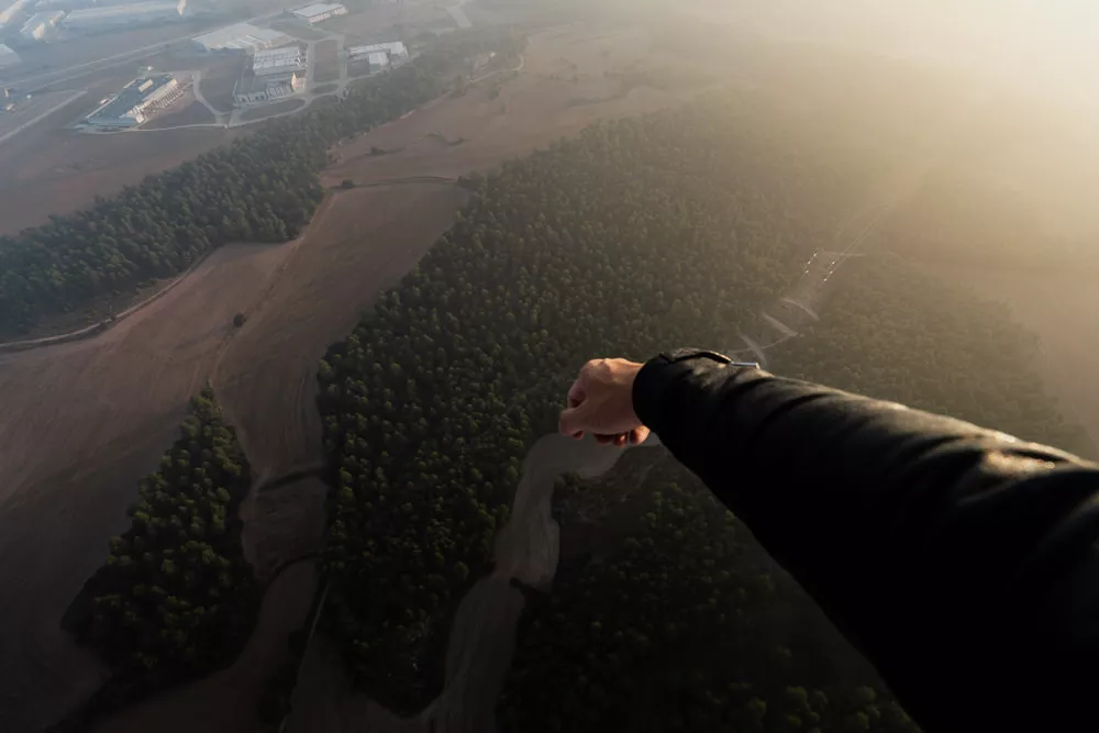 Arm hanging over hot air balloon basket in spain