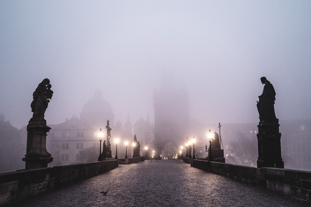 An empty Charles Bridge in the mist at dawn