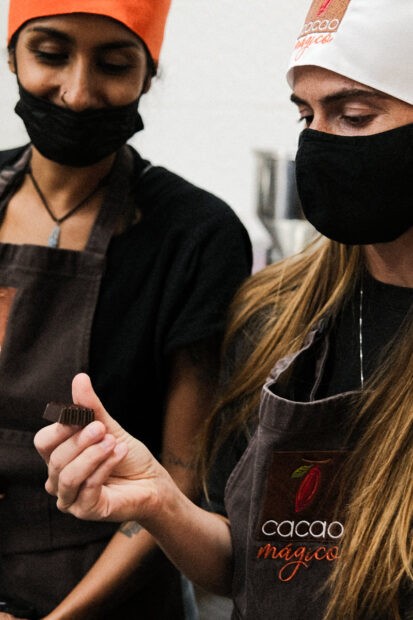 Masked woman looking at an empty chocolate cup