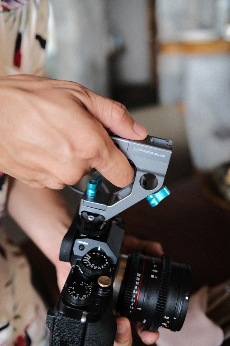 Hand holding Kondor Blue remote top trigger on Fujifilm X-T4 camera