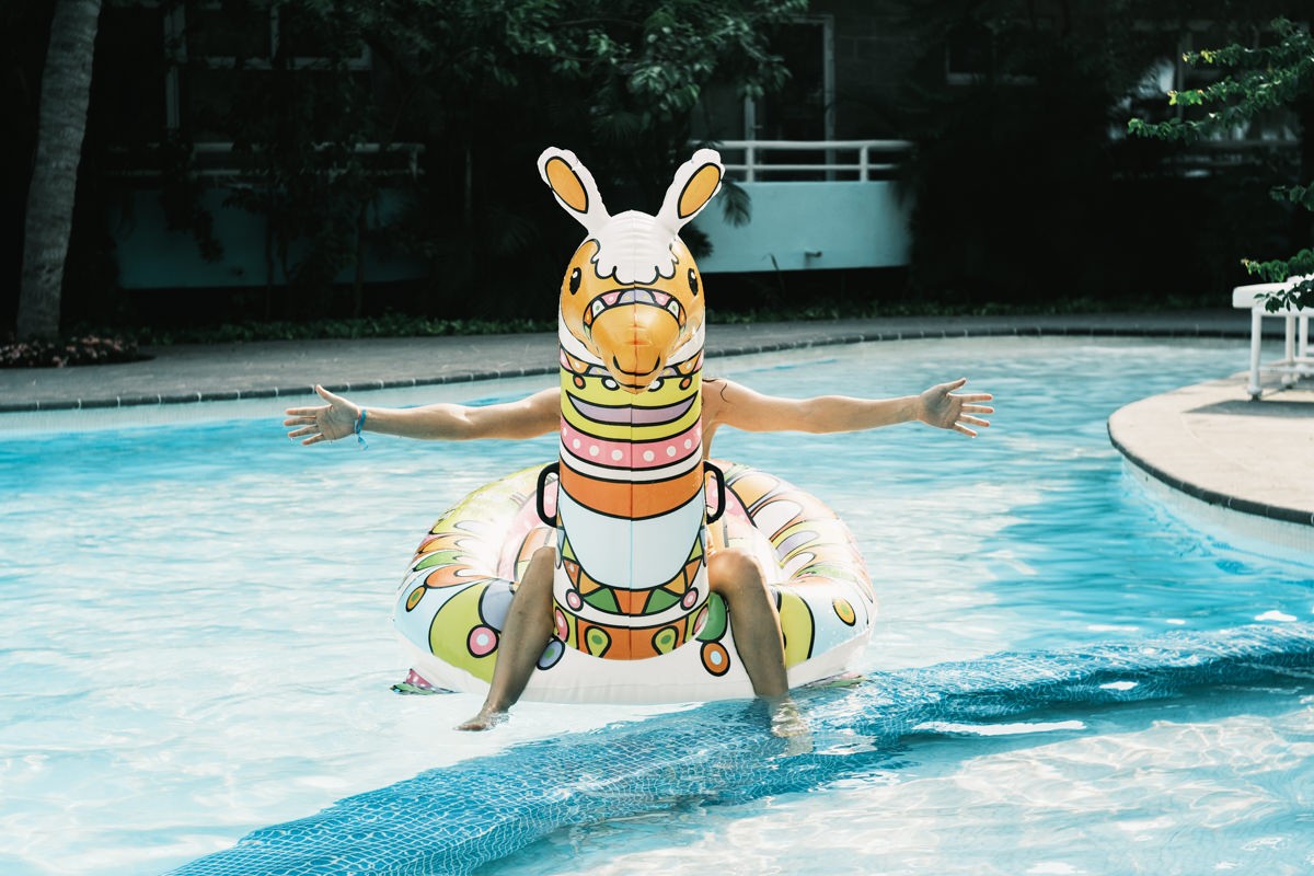 Girl sitting on Giana llama pool float