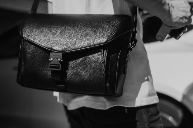 Black and white photo of man wearing Grams28 172 Camera Sling Bag