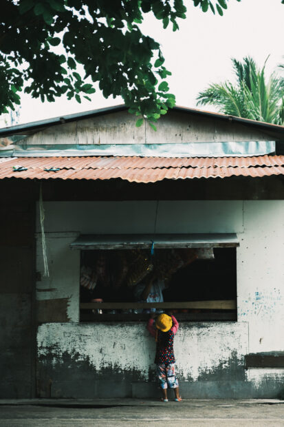 Girl buying snacks at a shop on Mabul Island