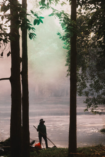 Cleaners working on lake behind angkor wat