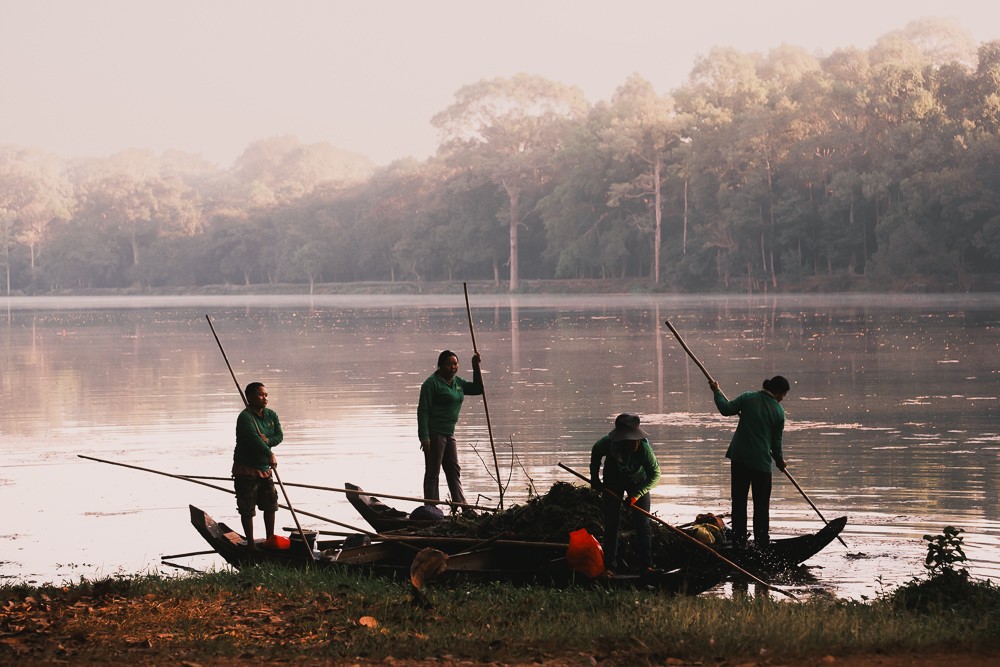 group of woman cleaning lake with small boat at Angkor Wat
