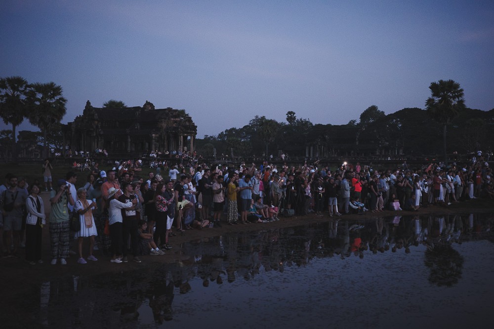 Crowd in front of reflecting pool at Angkor Wat waiting for sunrise 