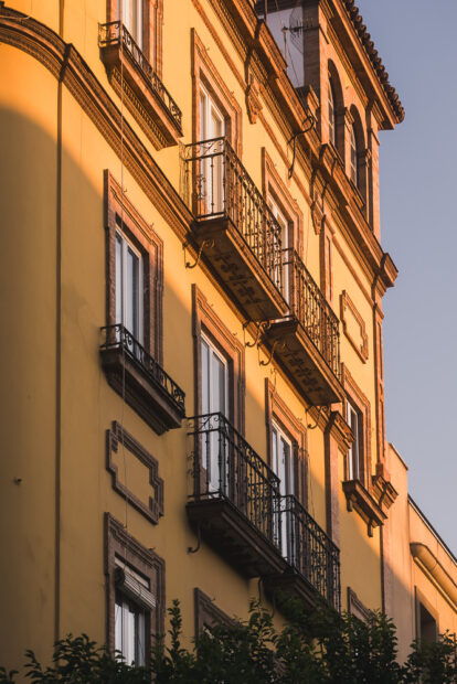 Photo of sun setting on colorful building in Barrio Santa Cruz neighbhorhood in Sevilla
