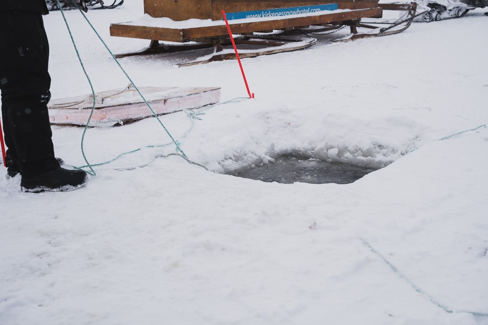 Square ice hole to pull king crab traps from under water in Norway