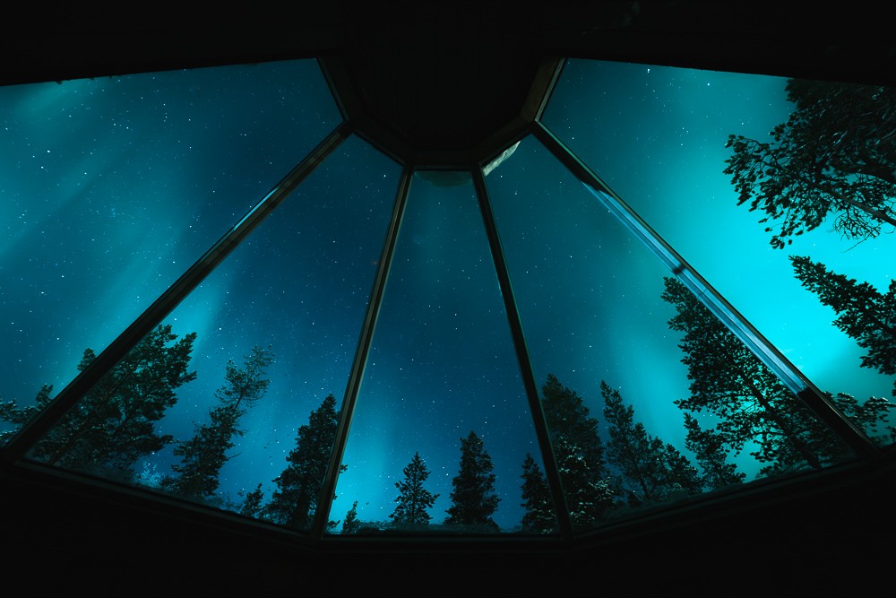 Northern lights through glass roof window in Saariselka Lapland Finland
