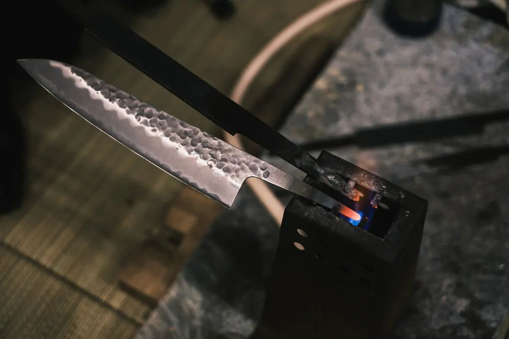 Hammered Gyuto blade in Japan with handle being heated.