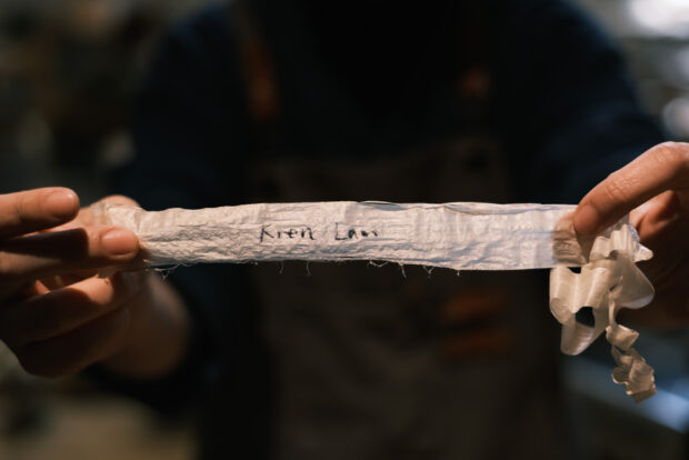Paper thin shaving from wood block with name on it