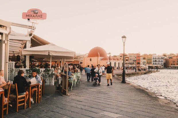 People walking and having dinner at Chania harbor at sunset