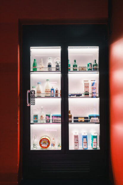 Speakeasy door behind refrigerator at Neonia Porto