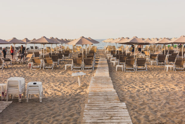 Rethymno Beach with sunbeds and umbrellas at sunset