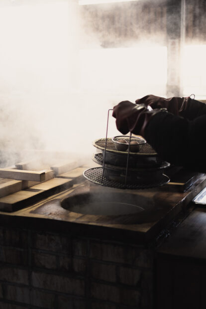 Customer putting in trays of food for steaming at Jigokumushi Kobo Kannawa