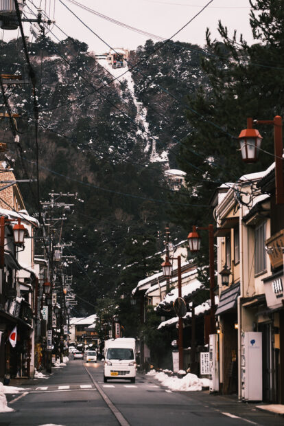 Snowy Kinosaki Onsen street with ropeway in the background