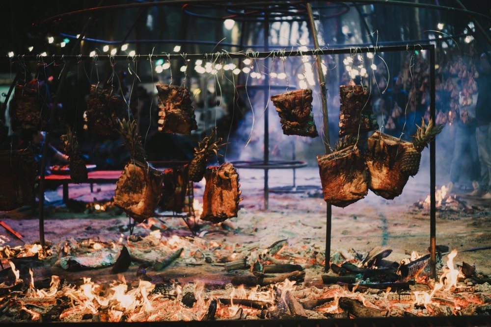 Meat grilling at metal dome frame at Chefs on Fire Cascais