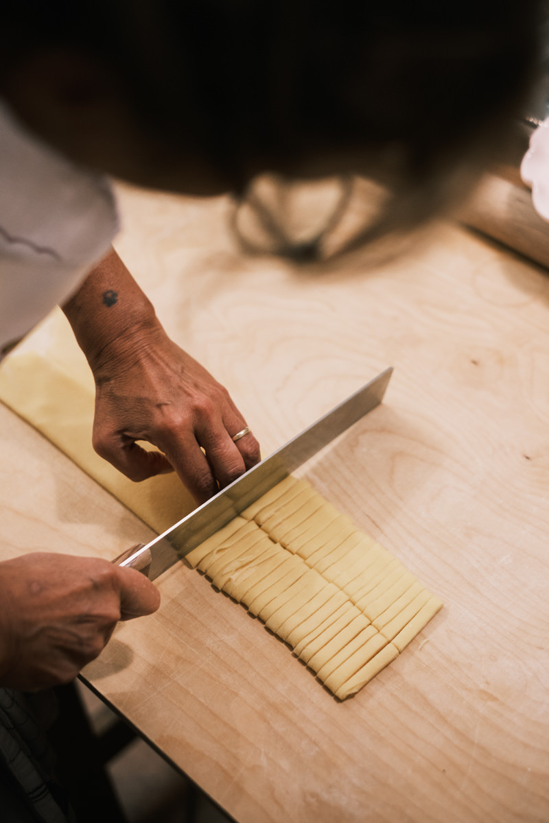 Cutting fresh tagliatelle for pasta making class in Bologna